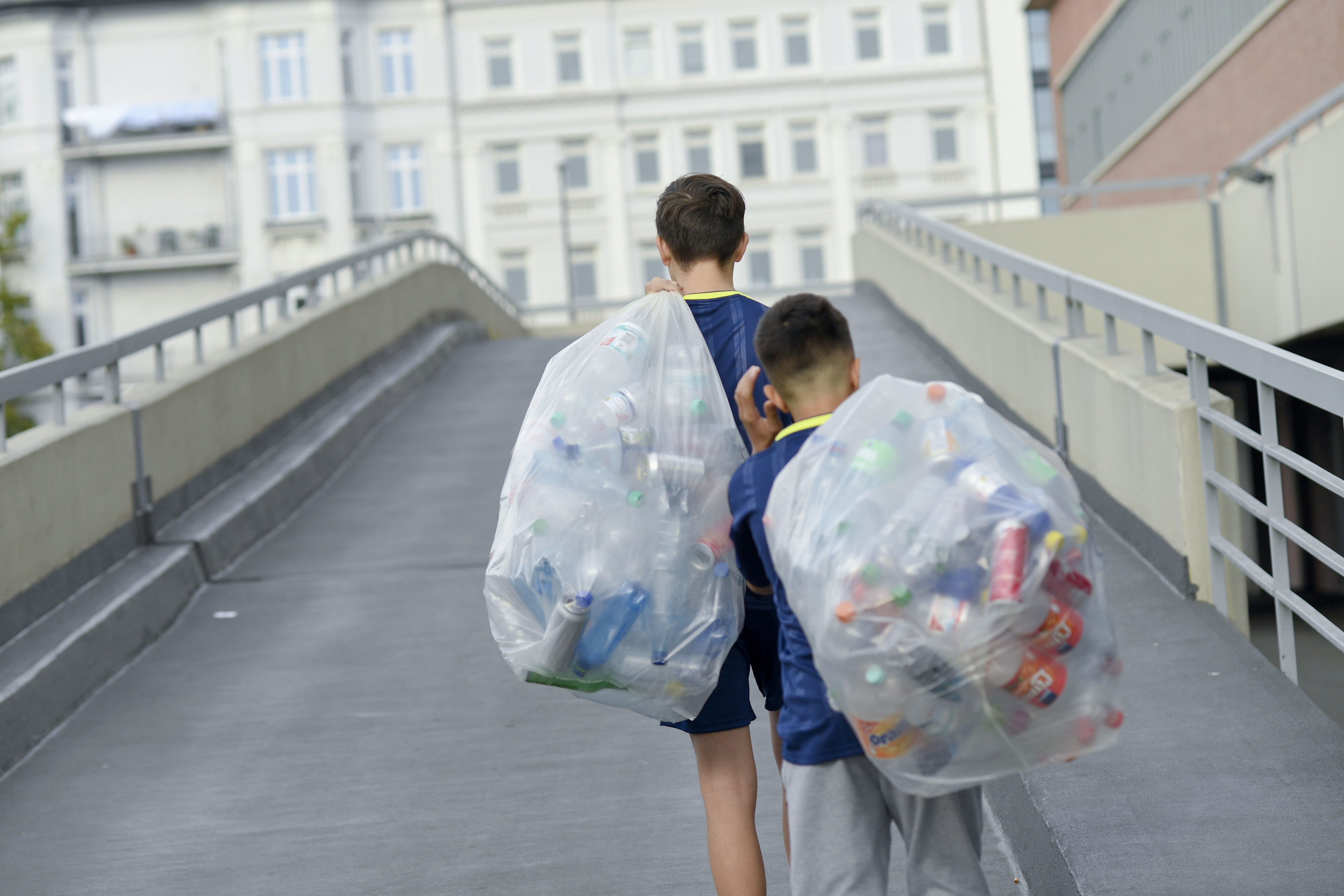 Boys carrying trash bags